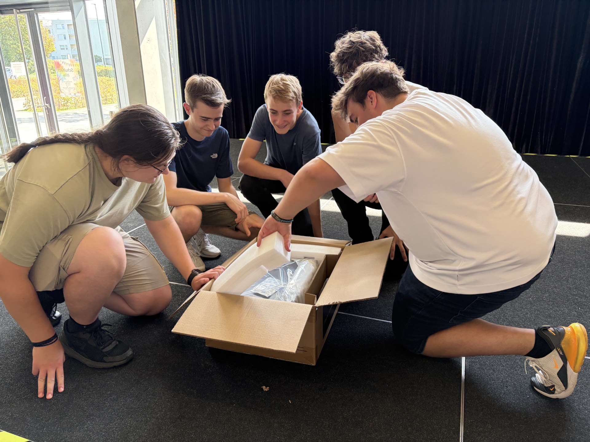 Das Team Veranstaltungstechnik der Gesamtschule Hürth packt die neue Stagebox auf der Bühne aus.